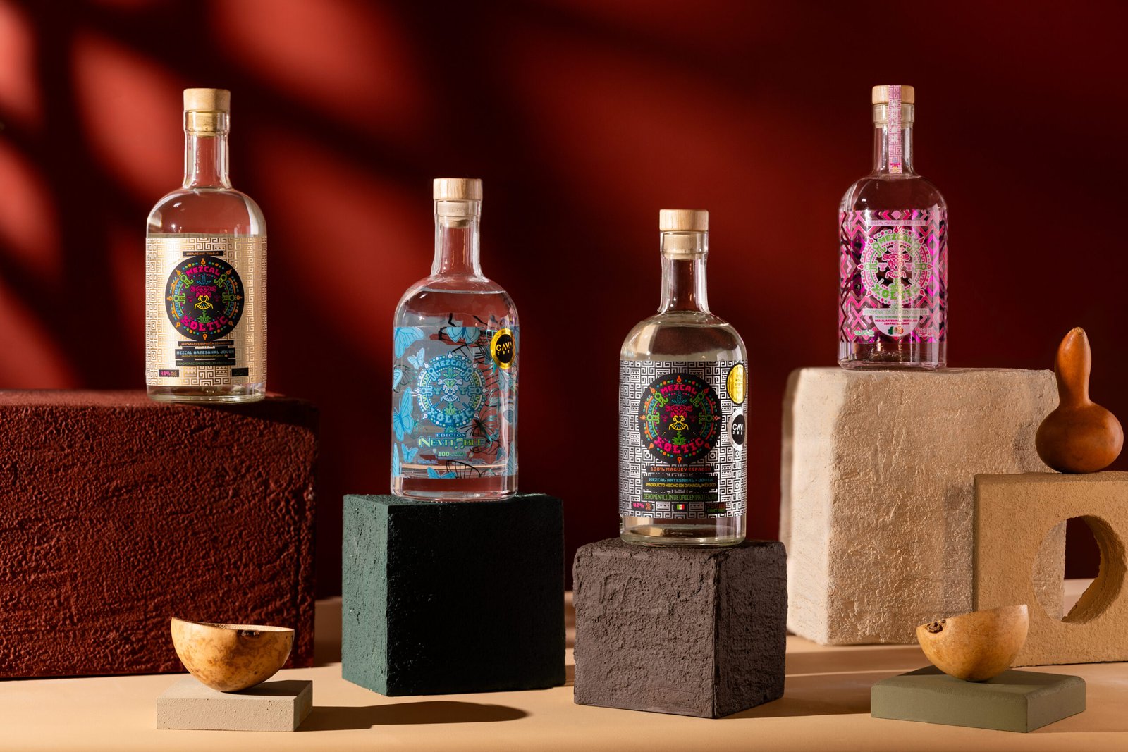 Botellas de Mezcal Xoltic Spirits con artesanías oaxaqueñas sobre fondo oscuro
